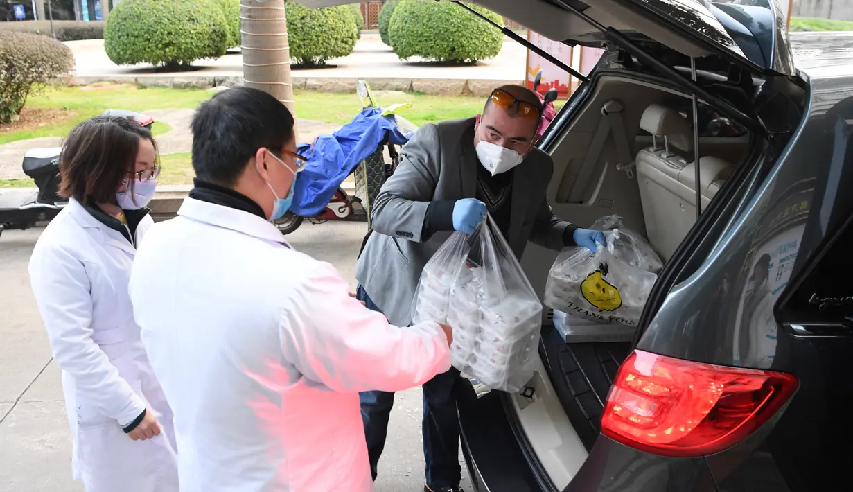 Alaaddin Colak (kanan) membawakan makanan gratis buatan restorannya untuk para pekerja medis di Fuzhou, China, 9 Februari 2020. Di tengah mewabahnya virus corona, Alaaddin dan istrinya memutuskan untuk menyediakan makanan gratis bagi para petugas pencegahan epidemi setempat. (Xinhua/Jiang Kehong)