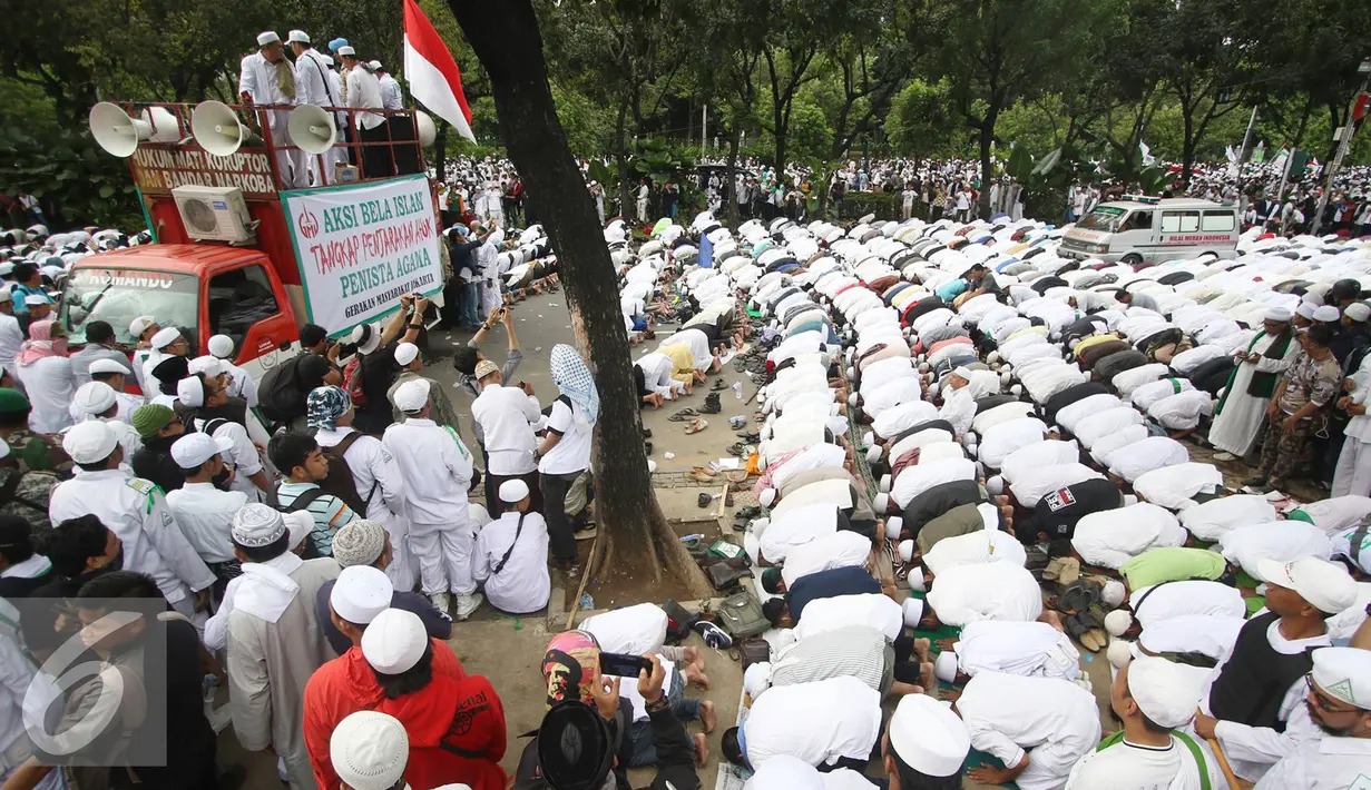 Ribuan massa ormas Islam melaksanakan salat saat mendatangi Balai Kota Jakarta, Jumat (14/10). Mereka menuntut agar Gubernur DKI Basuki Tjahaja Purnama ditindak terkait ucapannya yang dianggap melecehkan agama. (Liputan6.com/Immanuel Antonius)