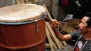 Pak Edot sang perajin bedug tampak mengecet sebuah drum.  (Liputan6.com/Faizal Fanani)