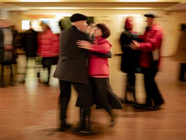 Sepasang lansia menari di Stasiun Kereta Bawah Tanah Teatralna, Kiev, Ukraina, 5 Maret 2023. Puluhan pensiunan menari selama lebih dari dua jam dalam acara akhir pekan yang telah berlangsung selama puluhan tahun dan hanya sempat terganggu oleh invasi Rusia ke Ukraina. (AP Photo/Vadim Ghirda)