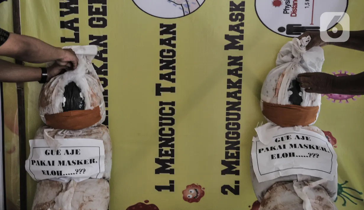 Pekerja memasang boneka pocong di Kantor Kecamatan Senen, Jakarta, Kamis (13/8/2020). Pemkot Jakpus menyiapkan peti mati dan boneka pocong untuk dipajang di setiap kecamatan sebagai peringatan akan bahaya Covid-19 dan imbauan untuk tidak mengabaikan protokol kesehatan. (merdeka.com/Iqbal Nugroho)