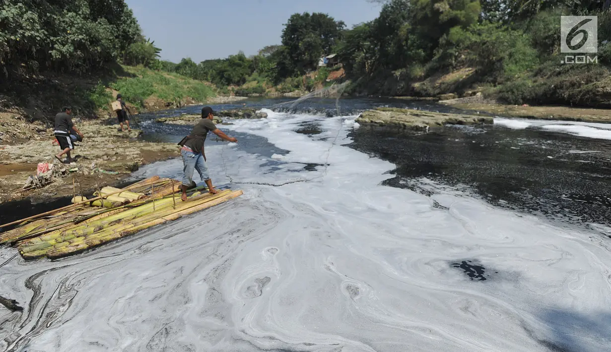 Warga mencari ikan di aliran Sungai Cileungsi yang berwarna hitam pekat di kawasan Bojong Kulur, Gunung Putri, Kabupaten Bogor, Jawa Barat, Selasa (23/7/2019). Air Sungai Cileungsi diduga  tercemar limbah pabrik sehingga menyebabkan ikan mati dan menimbulkan bau tak sedap. (merdeka.com/Arie Basuki)