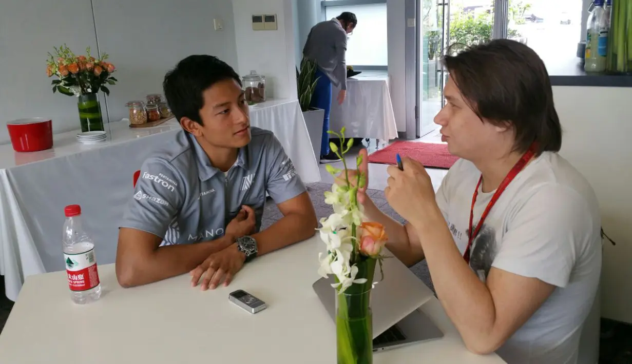 Rio Haryanto serius mendengar pertanyaan wartawan saat sesi wawancara di paddock Manor Racing di Sirkuit Internasional Shanghai, China, (14/4/2016). (Bola.com/Rio Haryanto Media)