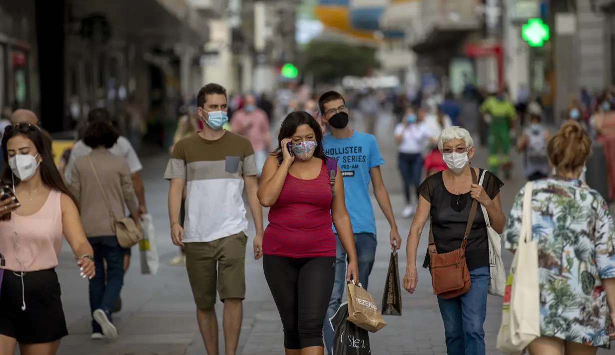 Sejumlah orang yang mengenakan masker untuk mencegah penyebaran COVID-19 berjalan di Madrid, Spanyol, Rabu (16/9/2020). Madrid akan memberlakukan penguncian selektif di daerah perkotaan tempat COVID-19 menyebar lebih cepat. (AP Photo/Manu Fernandez)