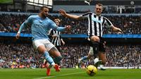 Bek kanan Manchester City, Kyle Walker mencoba lepas dari gangguan bek kiri Newcastle United, Dan Burn dalam lanjutan Premier League 2022/2023, Sabtu (4/3/2023) (AFP/Paul Ellis)