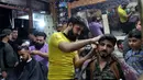 Sejumlah pria mencukur rambut jelang Hari Raya Idul Fitri di Kota Idlib, Suriah, Jumat (22/5/2020). Umat muslim seluruh dunia bersiap menyambut Idul Fitri yang sekaligus menandai berakhirnya bulan suci Ramadan. (OMAR HAJ KADOUR/AFP)