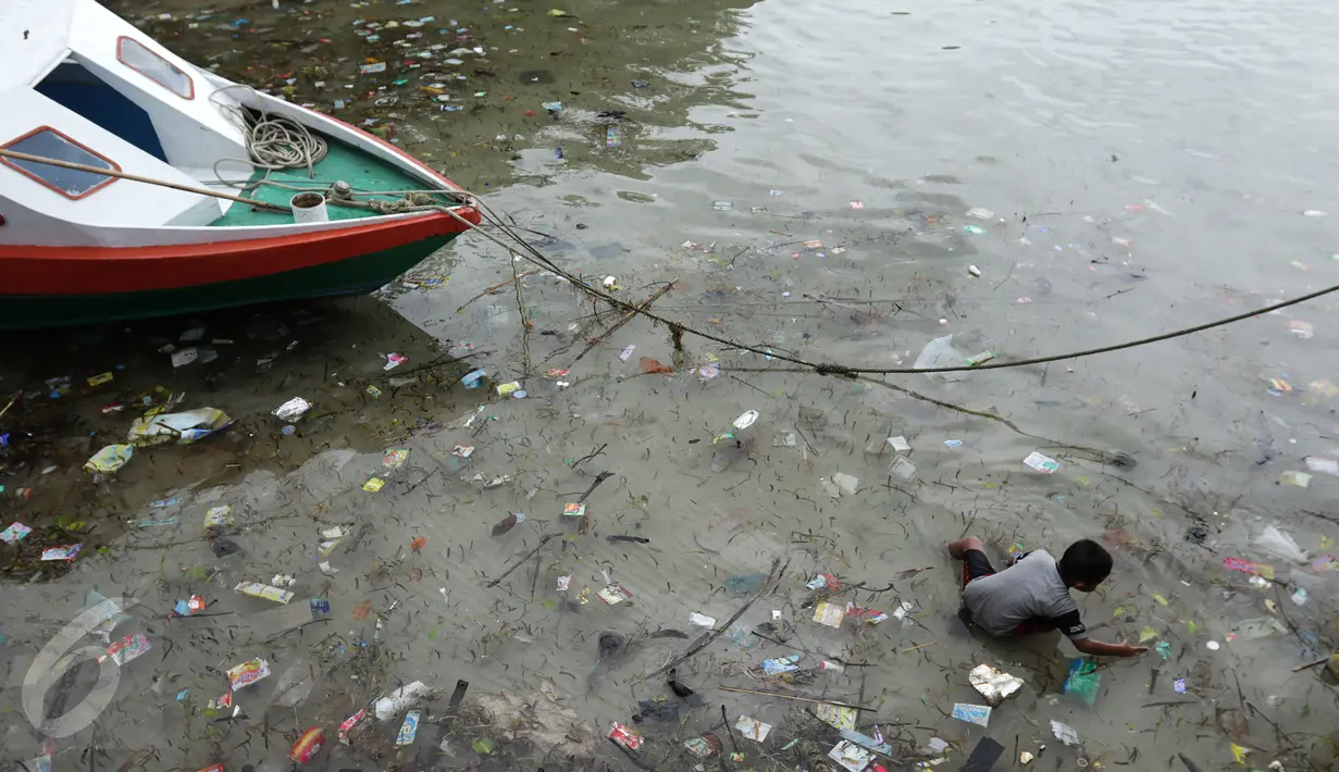 Seorang anak mencari ikan di pinggir dermaga Pulau Bunaken, Manado, yang dipenuhi sampah, Sabtu (17/12). Permasalahan sampah destinasi wisata nomor satu di Sulawesi Utara itu menjadi masalah klasik yang tak pernah terpecahkan. (Liputan6.com/Fery Pradolo)