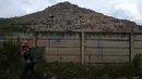 Seorang pemulung berjalan dekat gunungan sampah di kawasan Tempat Pengolahan Sampah Terpadu (TPST) Bantar Gebang, Bekasi, Jawa Barat, Selasa (17/1/2023). Sebelumnya, mantan Gubernur DKI Jakarta Anies Baswedan telah melakukan praperesmian fasilitas pengolahan sampah itu meski pembangunannya belum rampung pada Senin, 10 Oktober 2022. (merdeka.com/Imam Buhori)