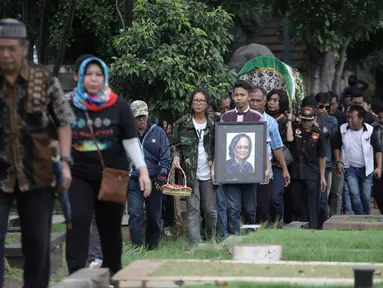 Sejumlah keluarga dan kerabat mengantarkan jenazah Vokalis grup band legendaris Koes Plus, Yon Koeswoyo untuk dimakamkan di TPU Tanah Kusir, Jakarta Selatan, Sabtu (6/1).  (Liputan6.com/Arya Manggala)