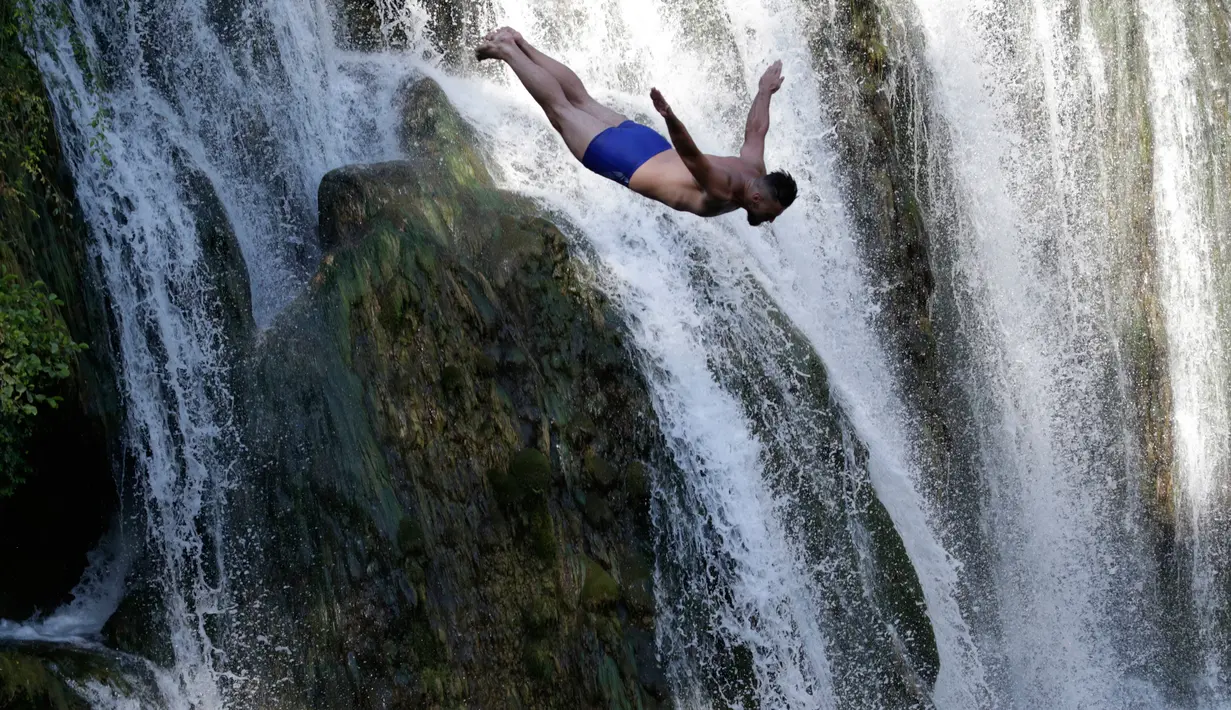 Peserta melompat dari atas air terjun saat mengikuti lomba melompat air terjun internasional ke-4 di Kota Jajce, Bosnia (5/8). Lomba melompat dari atas air terjun setinggi 21 meter ini diikuti oleh 23 peserta. (AP Photo/Amel Emric)