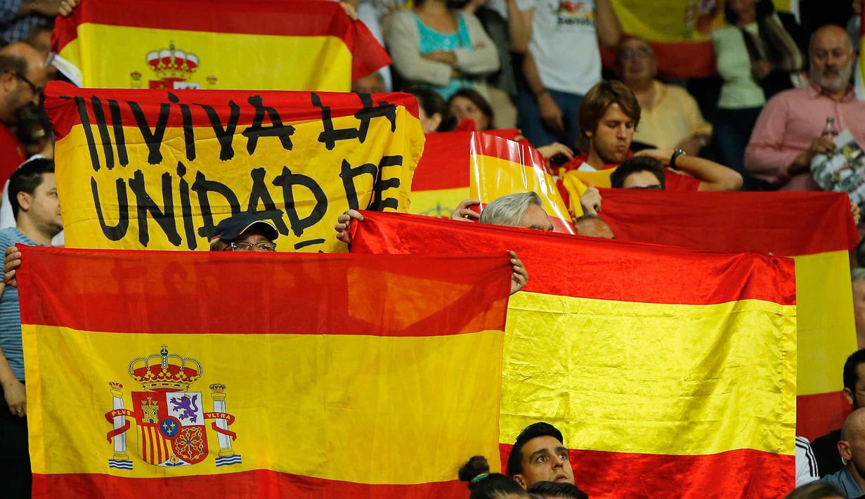 Suporter Real Madrid membentangkan bendera Spanyol saat pertandingan melawan Espanyol di Santiago Bernabeu, Spanyol (1/10).Suporter bentangkan Bendera pada menit ke-12. ( AP Photo/Paul White)