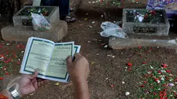 Umumnya para peziarah membawa buku Surat Yasin saat melakuan ziarah kubur, Karet Bivak, Jakarta, Sabtu (18/7/2015). Ziarah kubur dilakukan umat muslim untuk mendoakan mendiang keluarga dan kerabat mereka yang telah meninggal. (Liputan6.com/JohanTallo)