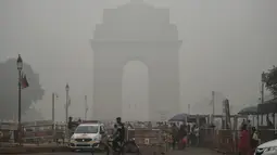 Turis mengunjungi India Gate dalam kondisi kabut asap tebal di New Delhi, Minggu (3/10/2019). Polusi di New Delhi disebabkan asap kembang api dalam Festival Diwali dan kabut asap akibat pembukaan lahan di pinggiran kota dan negara bagian di sekitarnya. (Photo by Sajjad  HUSSAIN / AFP)
