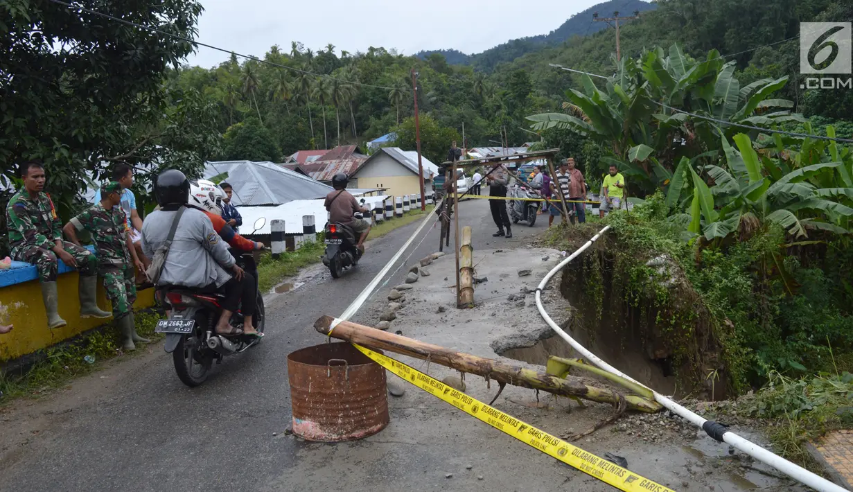 Kendaraan melintas dekat lokasi jalan longsor di Desa Bondawuna, Kabupaten Bone Bolango, Gorontalo, Selasa (30/4/2019). Hujan yang mengguyur wilayah Kabupaten Bone Bolango mengakibatkan empat desa di Kecamatan Suwawa Selatan, dan Bulango Timur Bone Bolango banjir. (Liputan6.com/Arfandi Ibrahim)