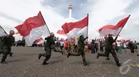 Sejumlah prajurit TNI AD membawa bendera dalam aksi teatrikalnya di pameran alutsista di kawasan Monas, Jakarta, Jumat (12/12/2014)  (Liputan6.com/Faizal Fanani)