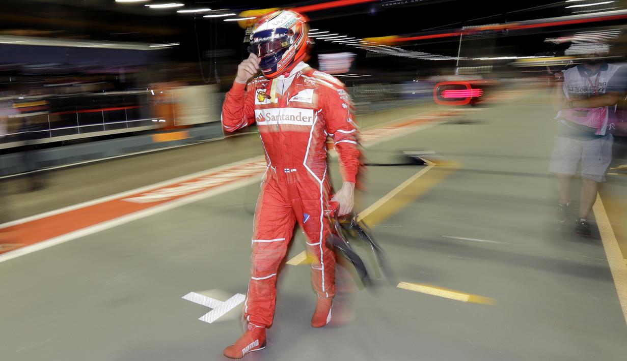 Pebalap Ferrari, Kimi Raikkonen melintasi pit area usai melakukan sesi latihan bebas F1 GP Singapura di Marina Bay City Circuit, (15/9/2017). (AP/Wong Maye-E)