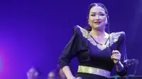 Titi Dj turut tampil menyanyikan Sang Dewi kenakan long dress dengan aksen emas di leher dan pinggang. [Foto: KLY/Adrian Utama Putra].