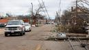 Mobil melewati pepohonan dan kabel listrik yang tumbang setelah tornado di Chestnut Blvd, Selma, Alabama, Amerika Serikat, 13 Januari 2023. Semua kematian akibat tornado yang dilaporkan di Alabama terjadi di Autauga County, yang terletak di antara Kota Montgomery dan Selma. (AP Photo/Stew Milne)