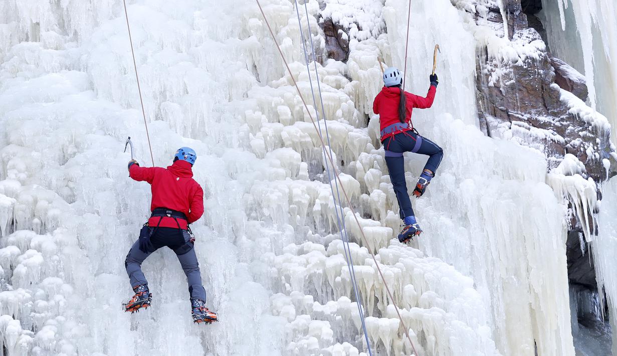 Orang-orang memanjat dinding es buatan di desa Vir, Republik Ceko, Minggu (14/2/2021). Ketika suhu turun di Republik Ceko, pemanjat tebing memanfaatkan kondisi beku dengan mengubah permukaan batu menjadi dinding es setinggi 20 meter untuk pendaki. (AP Photo/Petr David Josek)