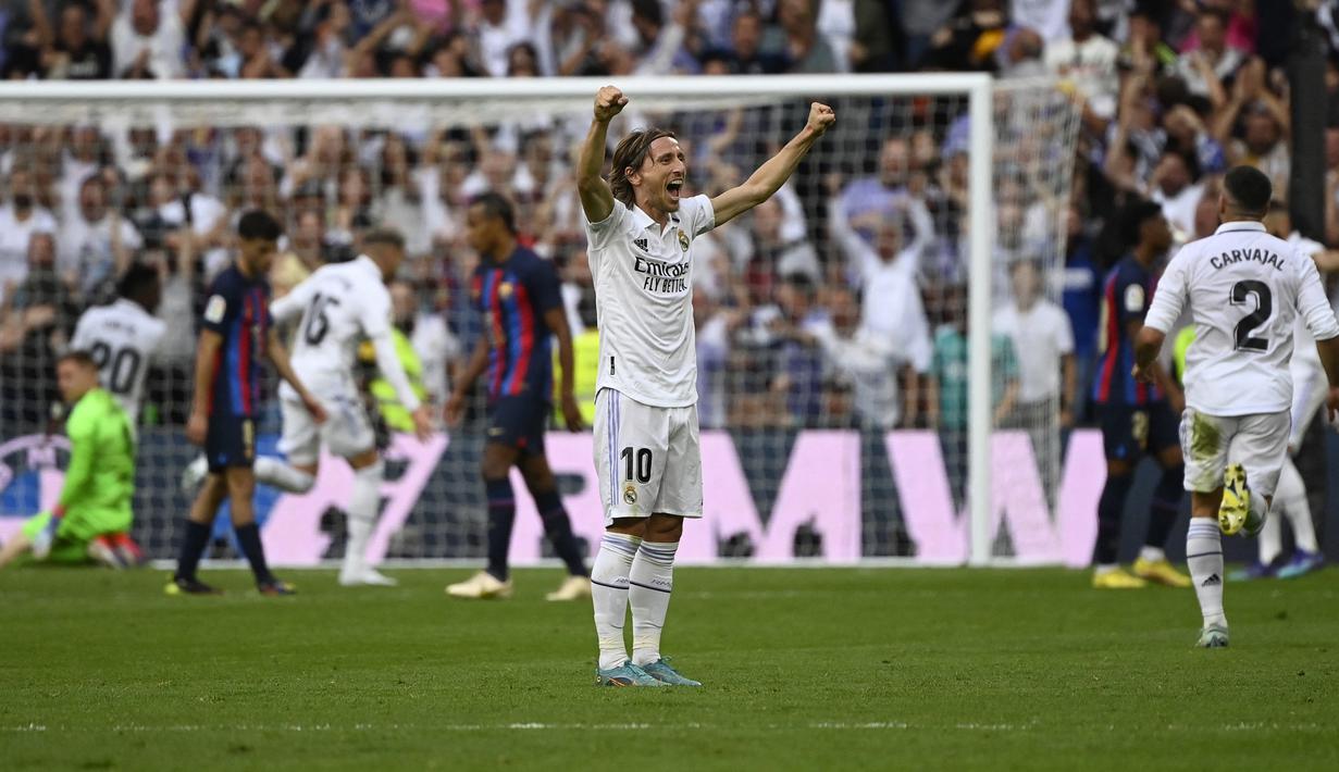 Pemain Real Madrid, Luka Modric merayakan gol ke gawang Barcelona pada laga Liga Spanyol 2022/2023 di Santiago Bernabeu Stadium, Madrid (16/10/2022). Real Madrid menjadi klub Spanyol yang paling sering mengalahkan Barcelona di semua ajang. Dari total 252 laga, Barcelona tercatat kalah 102 kali dan menang dalam 99 laga. (AFP/Pierre-Philippe Marcou)
