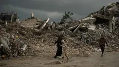 Warga Palestina berjalan melewati reruntuhan di tengah cuaca buruk Kota Gaza, Kamis 11 Desember 2025. Bencana baru mengancam ratusan ribu warga Palestina yang mengungsi di Jalur Gaza. (AP Photo/Jehad Alshrafi)