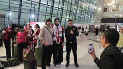 Atlet Voli, Megawati Hangestri Pertiwi, melayani permintaan foto bersama fans setelah acara penyambutan atlet SEA Games 2025 di Bandara Soekarno-Hatta, Tangerang, Selasa (16/12/2025). (Bola.com/M Iqbal Ichsan)