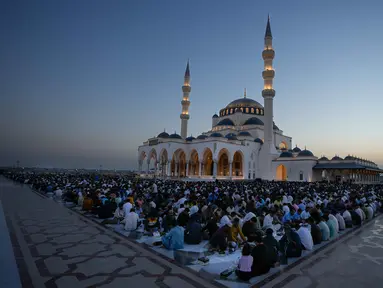 Para jamaah Muslim menunggu sebelum memulai Iftar, yaitu makan atau minum yang mengakhiri puasa seharian, selama bulan suci Ramadan di Masjid Agung Sharjah, dekat Dubai, Uni Emirat Arab, Jumat 27 Februari 2026. Masjid Agung Sharjah merupakan salah satu yang terbesar di Uni Emirat Arab. (AP Photo/Altaf Qadri)