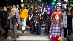 Sejumlah orang turun ke jalan dengan mengenakan kostum zombie saat mengikuti Zombie Walk dalam Festival Purim di Tel Aviv, Israel (3/3). Liburan Purim ini dirayakan dengan parade dan pesta kostum. (AP Photo/Ariel Schalit)