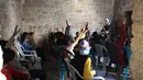 Anak-anak Palestina menghadiri kelas di sekolah bersejarah "Al-Kamaliya al-Othmanya" di Kota Tua Gaza yang menjadi bagian dari inisiatif sukarelawan yang diorganisir oleh para guru pengungsi, di Kota Gaza pada 2 November 2025. Pembukaan kembali sekolah-sekolah di Gaza memungkinkan anak-anak melanjutkan pendidikan formal setelah terhenti selama sekitar dua tahun akibat konflik. (Omar AL-QATTAA/AFP)