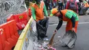 Petugas PPSU membersihkan sampah sisa perayaan Hari Buruh Internasional di kawasan Silang Barat Daya Monas, Jakarta, Rabu (1/5). Buruh dari sejumlah perkumpulan merayakan Hari Buruh Internasional dengan aksi damai. (Liputan6.com/Helmi Fithriansyah)
