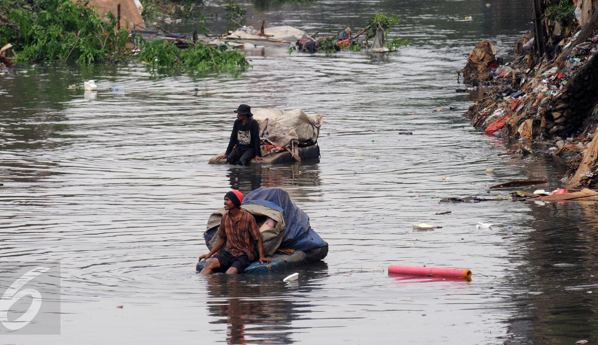 Pemulung melintasi Kali Ciliwung usai mengais sisa pembongkaran rumah warga KampungPulo, Jakarta, Jumat (21/8/2015). Penggusuran terkait rencana Pemprov DKI Jakarta yang akan melakukan normalisasi Kali Ciliwung. (Liputan6.com/Helmi Fithriansyah)