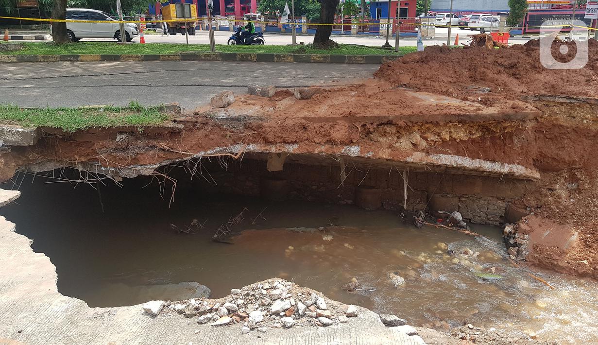 Jalan ambles di ruas Jalan Boulevard, Grand Depok City (GDC), Kota Depok, Jawa Barat, Selasa (13/4/2021). Lubang tanah yang longsor tidak terlalu besar namun tetap terlihat berbahaya jika dibiarkan. (Liputan6.com/Herman Zakharia)