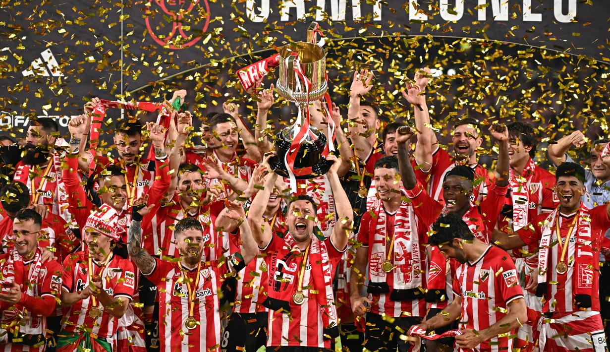 Pemain Athletic Bilbao melakukan selebrasi setelah menjuarai Copa del Rey di Stadion Olimpico de Sevilla, Minggu (7/4/2024). Bilbao mengakhiri kutukan 40 tahun dengan menjadi kampiun Copa del Rey 2023/2024. (AFP/Javier Soriano)