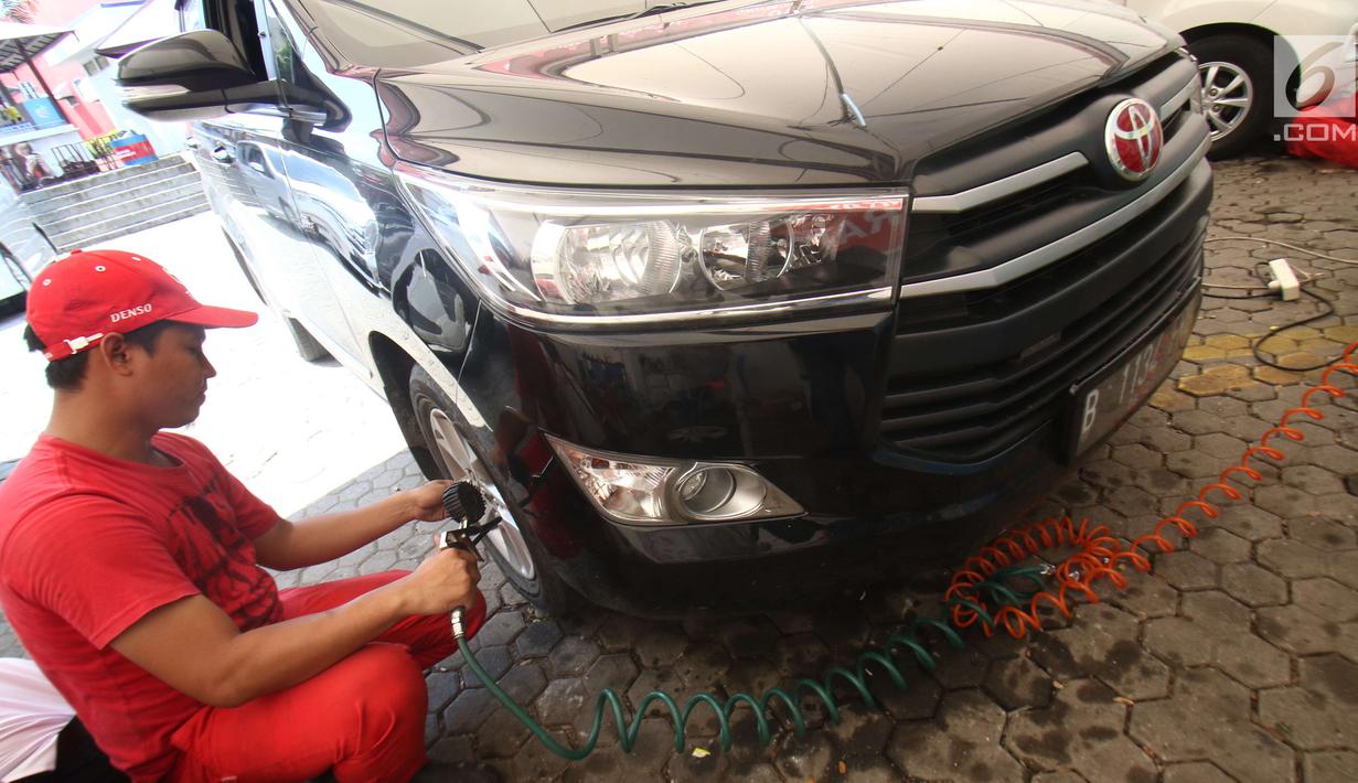Teknisi memeriksa kondisi ban di rest area 57 km, Karawang, Jawa Barat, Kamis (29/6). Selain servis para pelanggan mendapat fasilitas beristirahat di posko secara gratis. (Liputan6.com/Helmi Afandi)