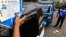 Supir bajaj sedang menempel stiker naik bajaj gas gratis di MRU PGN Station IRTI Monas, Jakarta, Minggu (14/08). Kegiatan ini merupakan bagian dari program BUMN Hadir Untuk Negeri. (Liputan6.com/Fery Pradolo).