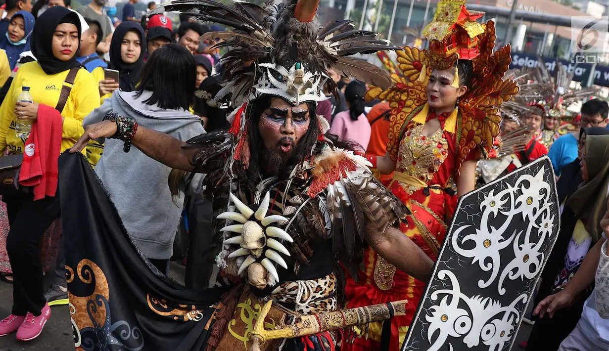 Kelompok seni budaya Kalimantan Selatan berpawai mengenakan pakaian adat saat pelaksanaan car free day di Jakarta, Minggu (1/7). Pawai tersebut diadakan untuk mengenalkan budaya Kalimantan Selatan kepada masyarakat. (Liputan6.com/Immanuel Antonius)