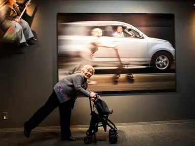 Seorang nenek bernama Kimiko Nishimoto berpose di depan karya foto-fotonya yang dipamerkan di Tokyo, Jepang (14/12). Kimiko Nishimoto adalah seorang nenek yang menjadi selebram dengan jumlah pengikut sebanyak 42 ribu. (AFP Photo/Behrouz Mehri)