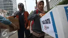 Karyawan Asia Pulp & Paper (APP) Sinar Mas membagikan takjil kepada pejalan kaki di kawasan Bundaran HI, Jakarta (24/6). (Liputan6.com/ Immanuel Antonius)