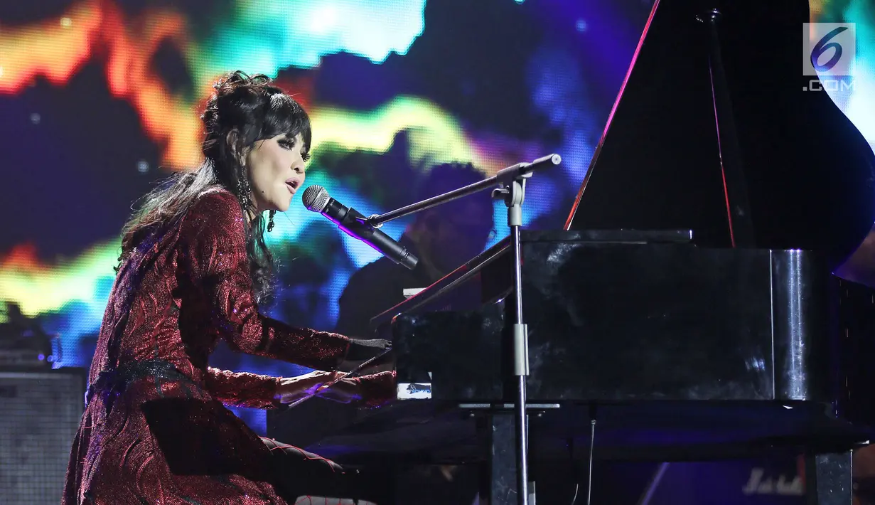 Penyanyi senior, Ita Purnamasari menunjukkan kemahirannya memainkan keyboard saat konser '3 Dekade Ita Purnamasari' di Jakarta, Jumat (8/12). Ita Purnamasari mempersembahkan konser spesial bersama suami, Dwiki Dharmawan. (Liputan6.com/Herman Zakharia)
