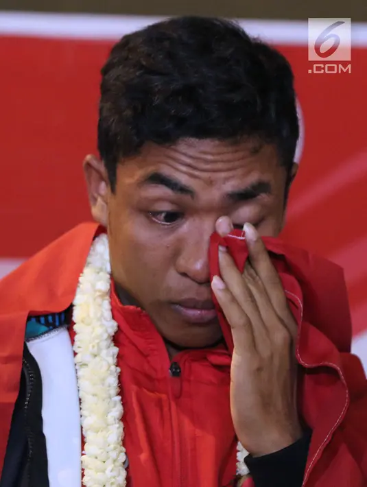 Pelari muda Indonesia, Lalu Muhammad Zohri mengusap mata saat upacara penyambutan di Terminal 3 Bandara Soetta, Tangerang, Selasa (17/7). Lalu M Zohri meraih emas lari 100m putra di Kejuaraan Dunia Atletik U-20. (Liputan6.com/Helmi Fithriansyah)