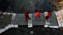 Wanita Hindu Nepal menyebrangi sungai Saali saat festival Swasthani Brata Katha di Kathmandu, Nepal, (24/1). Selama festival umat Hindu Nepal membaca kitab suci Hindu yang didedikasikan untuk dewi Swasthani dan Dewa Siwa. (AFP PHOTO/Prakash mathema)