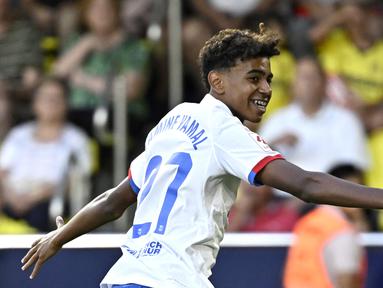 Pemain Barcelona, Lamine Yamal, merayakan gol ke gawang Villarreal pada laga Liga Spanyol 2023/2024 di Stadion La Ceramica, Minggu (27/8/2023). Barca menang dengan skor 4-3. (AFP/Javier Soriano)