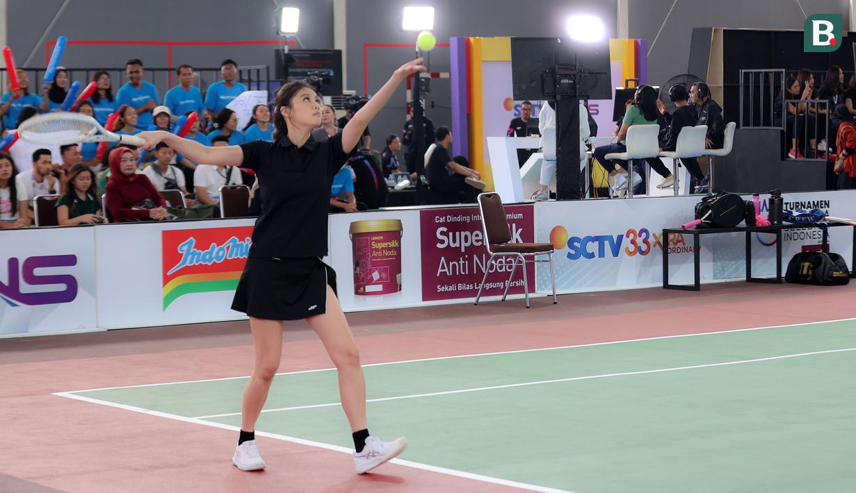 Aktris sekaligus model, Gege Elisa Joy Callista melakukan servis saat tampil pada pertandingan tenis nomor ganda campuran Turnamen Olahraga Selebriti Indonesia (TOSI) yang digelar di GOR UNJ, Jakarta, Sabtu (15/07/2023). Gege yang berpasangan dengan Ibnu Jamil berhasil mengalahkan pasangan Nagita Slavina dan Jeje Govinda dua set langsung (7-5, 7(7)-6(2)). (Bola.com/Abdul Aziz)