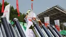 Seorang koki mempersiapkan untuk memasak makanan dengan kompor tenaga surya di Dezhou, Shandong Timur, Cina, 2 Agustus 2018. Dua lusin koki memasak pada festival masak menggunakan kompor tenaga surya di Cina. (AP Foto/Fu Ting)