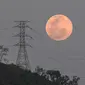 Bulan purnama muncul di balik menara tegangan tinggi El Avila di Caracas, Venezuela, Minggu (15/5/2022). Orang-orang di Amerika, Eropa, dan Afrika akan menyaksikan gerhana bulan total pada malam tanggal 15-16 Mei. (AP Photo/Matias Delacroix)