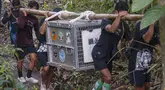 Tim konservasi bersama warga setempat membawa kandang transportasi berisi orangutan yang telah menjalani rehabilitasi di dekat Desa Batu Lapis, Kabupaten Ketapang, Kalimantan Barat, Kamis (29/10/2026). Sebanyak sembilan orangutan berhasil diselamatkan dari kebakaran hutan yang melanda habitat mereka di wilayah Ketapang pada Agustus dan September 2026. Setelah menjalani proses rehabilitasi, orangutan tersebut secara bertahap dilepasliarkan kembali ke habitat alaminya. Salah satunya adalah seekor induk orangutan bersama anaknya yang langsung memanjat pepohonan dan menghilang di antara rimbunnya kanopi hutan setelah kandang dibuka. (Ilham Pratama/AFP)