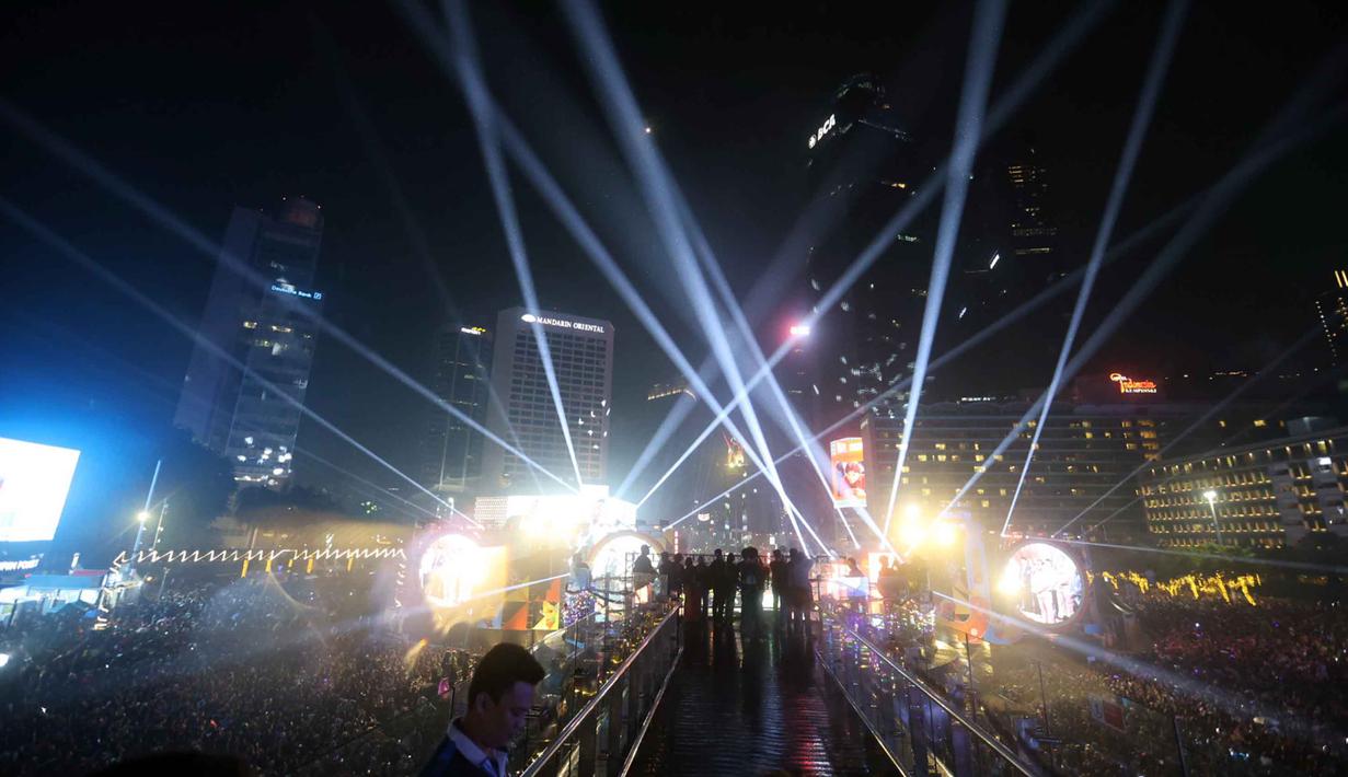 Warga pun antusias berfoto berlatar cahaya lampu. Tampak dalam foto, warga berfoto dengan latar cahaya lampu saat perayaan malam pergantian tahun di kawasan Bundaran Hotel Indonesia, Jakarta, Rabu (31/12/2025). (Kapanlagi.com/Budy Santoso)