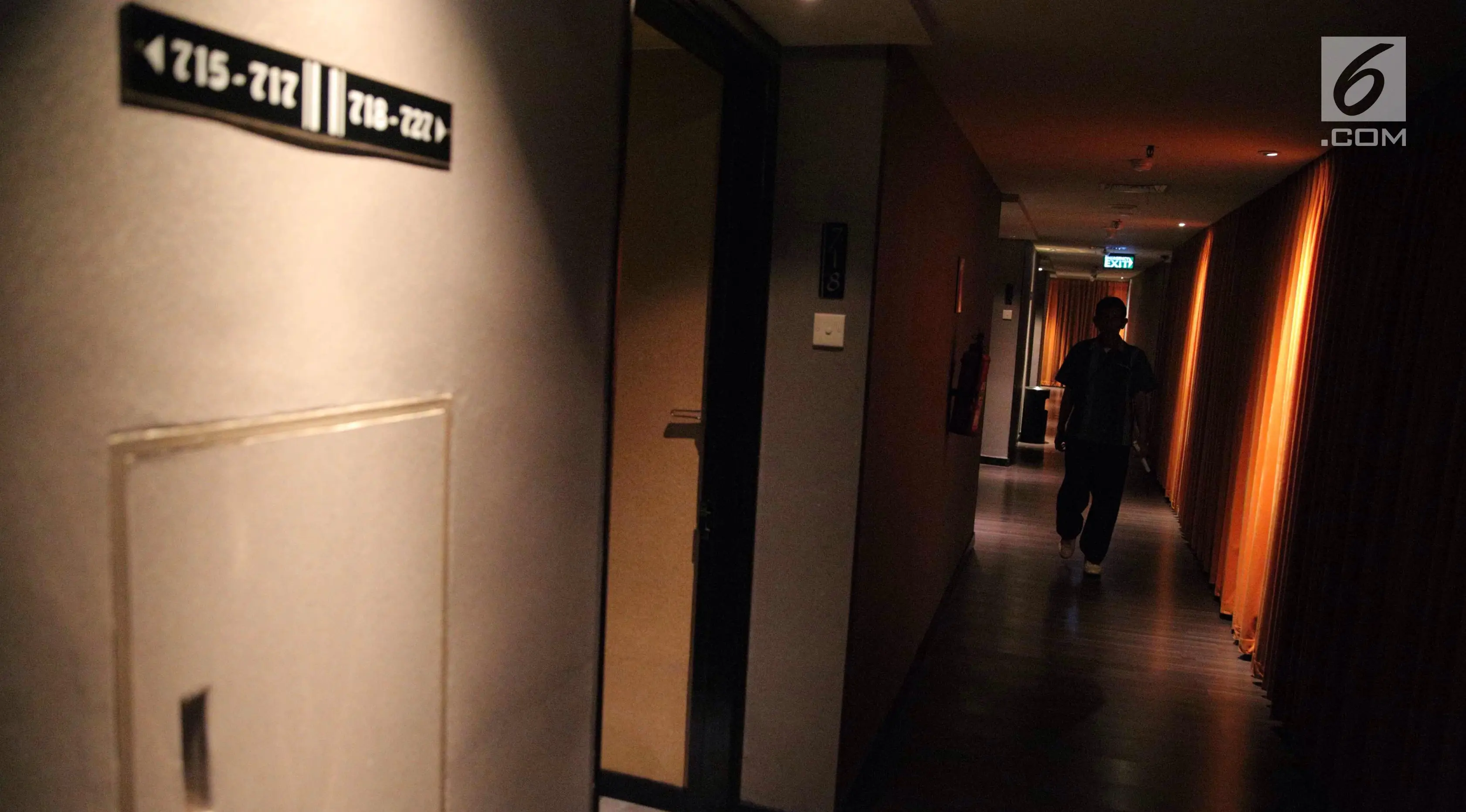 Seorang pria berjalan di lorong yang berada di lantai tujuh Hotel Alexis, Jakarta, Selasa (31/10). Suasana pencahayaan yang kurang dan udara dingin terasa di lantai itu. (Liputan6.com/Faizal Fanani)
