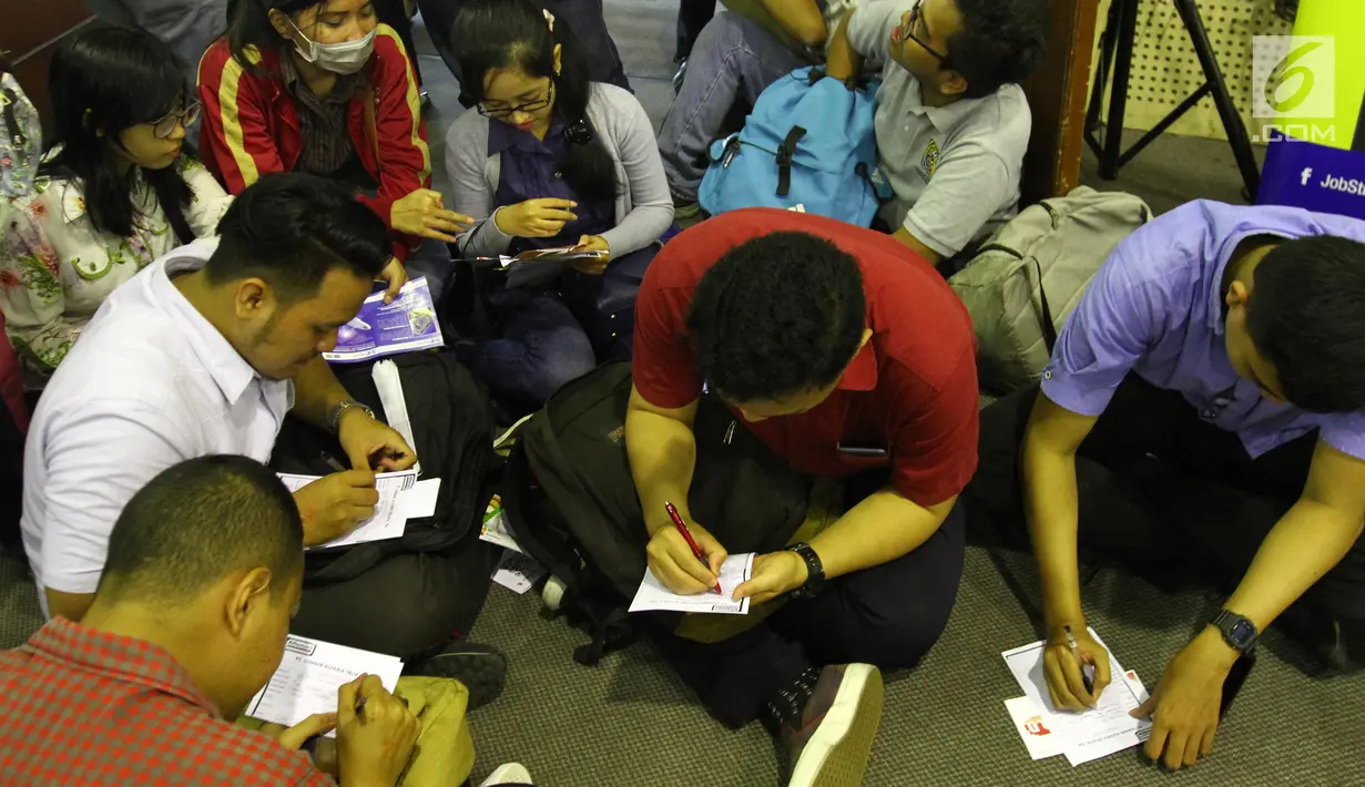 Sejumlah orang mengisi berkas saat akan memasukkan lamaran pada sebuah perusahaan dalam bursa kerja di Jakarta, Rabu (24/1). (Liputan6.com/Angga Yuniar)