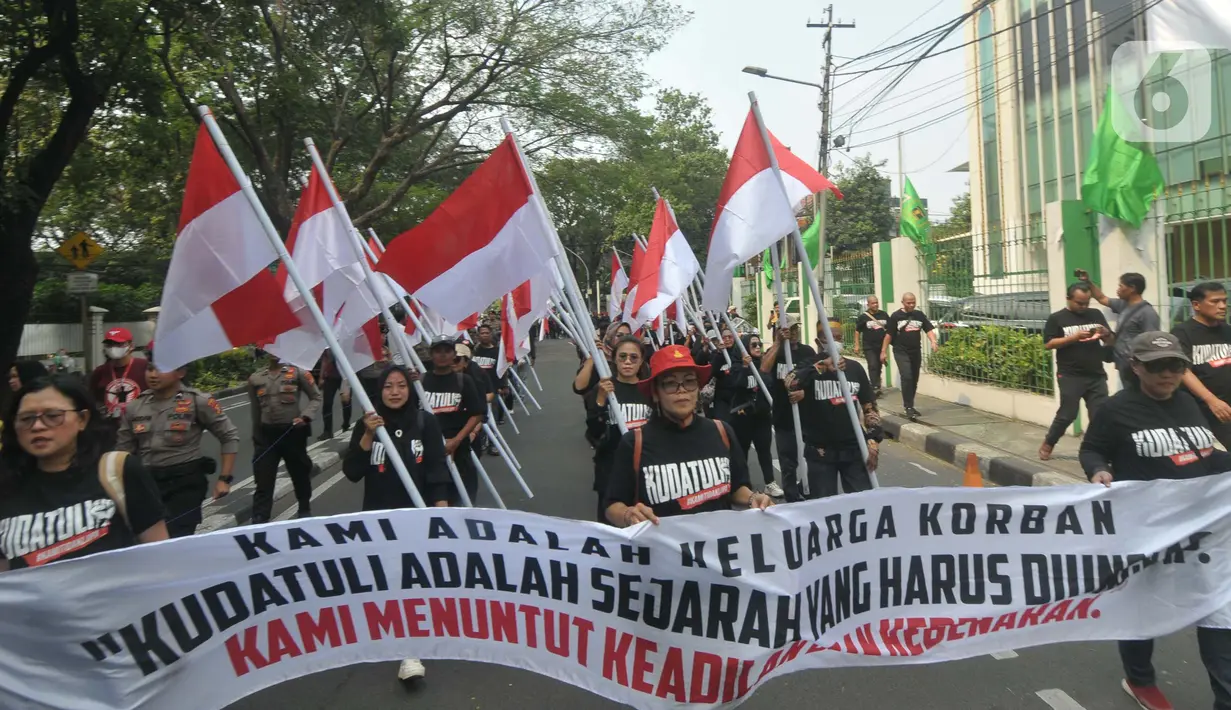 Ratusan orang melakukan aksi berjalan kaki sambal membawa poster dan bendera dari kantor Dewan Pimpinan Pusat (DPP) Partai Demokrasi Indonesia Perjuangan (PDIP) menuju gedung Komisi Nasional Hak Asasi Manusia (Komnas HAM), Jakarta, Jumat (26/7/2024). (merdeka.com/Imam Buhori)